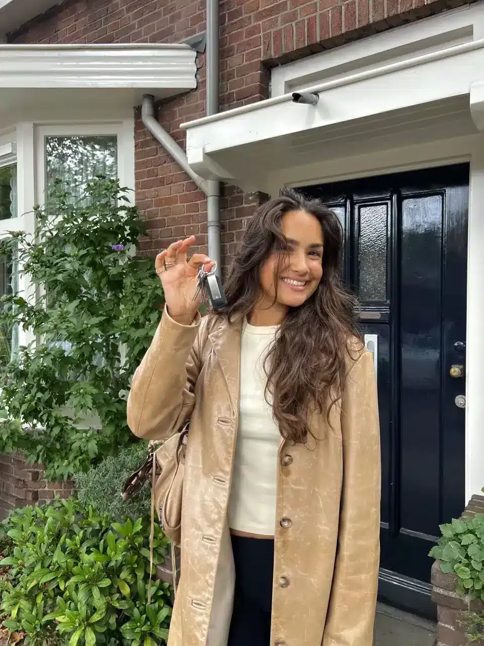 Sophia met sleutels voor een donkerblauwe deur, campagnefoto van RentSlam