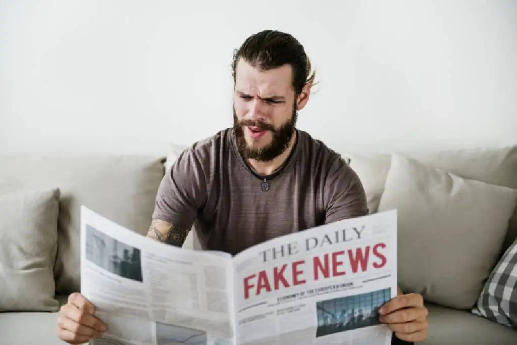 Man leest de krant over nep nieuws op de bank