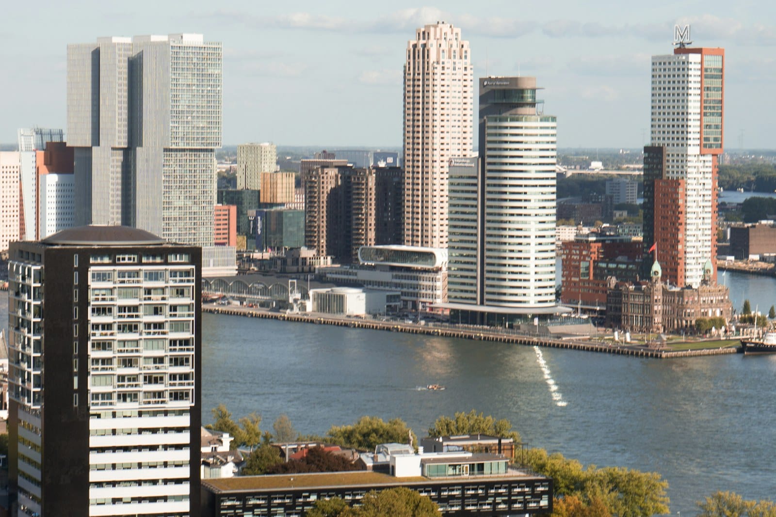 Daglichtfoto van de Rotterdamse skyline met moderne hoogbouw aan de Maas